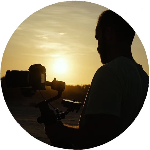 man recording a video on camera at sunset